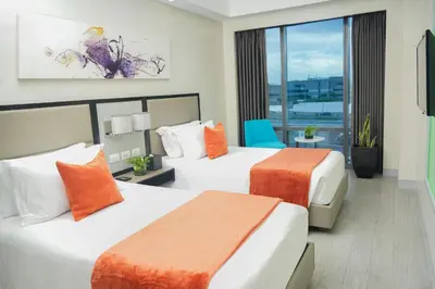 a hotel room with two beds and a window at Stay Across NAIA Terminal 3 in Newport City in Manila