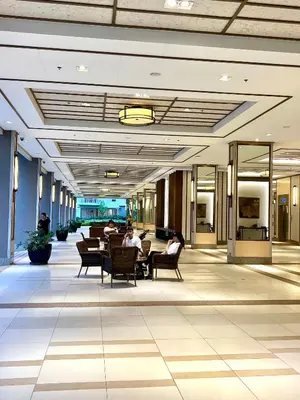 a lobby with people sitting in chairs in a building at Angels Place The Atherton, Manila Condo Near Airport in Manila