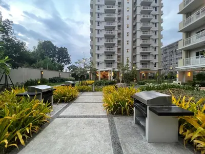 a courtyard of a building with benches and plants at Angels Place The Atherton, Manila Condo Near Airport in Manila
