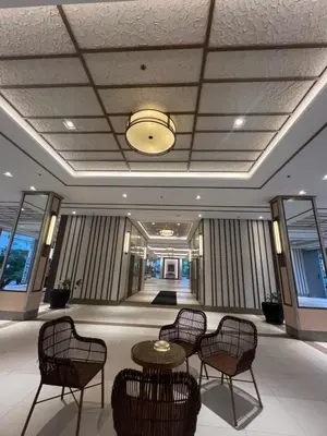 a lobby with chairs and tables in a building at Angels Place The Atherton, Manila Condo Near Airport in Manila