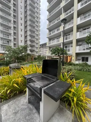 a bench in front of a large apartment building at Angels Place The Atherton, Manila Condo Near Airport in Manila