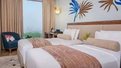 a hotel room with two beds and a blue chair at City Getaway in the Heart of Entertainment City in Manila