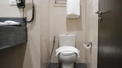 a bathroom with a toilet with a towel on it at City Getaway in the Heart of Entertainment City in Manila