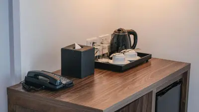 a table with a coffee maker and a telephone on it at City Getaway in the Heart of Entertainment City in Manila