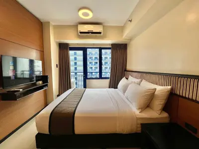 a hotel room with a bed and a window at Studio Condo by Sea Residences near MOA 02 in Manila