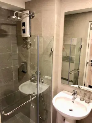 a bathroom with a glass shower and a sink at Studio Condo by Sea Residences near MOA 02 in Manila