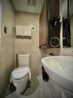 a bathroom with a toilet and a sink and a phone at Studio Condo by Sea Residences near MOA 02 in Manila