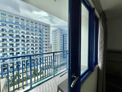 a balcony with a view of a large building at Studio Condo by Sea Residences near MOA 02 in Manila