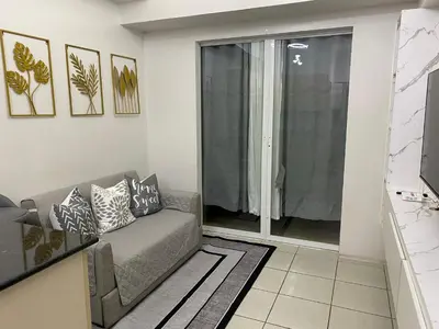 a living room with a couch and a sliding glass door at AMA Tower Residences - Liam Kyro Staycation Place in Manila