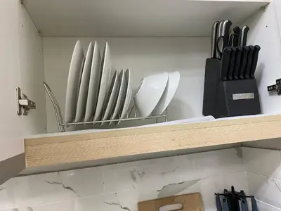 a wooden shelf with plates and utensils on it at AMA Tower Residences - Liam Kyro Staycation Place in Manila