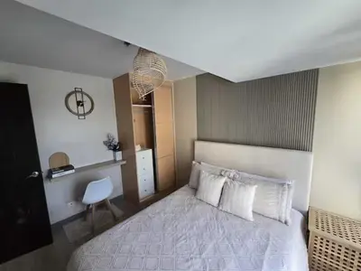 a bedroom with a white bed and a chair at Modern Comfort & Snap Worthy with Pool, Gym & More in Manila