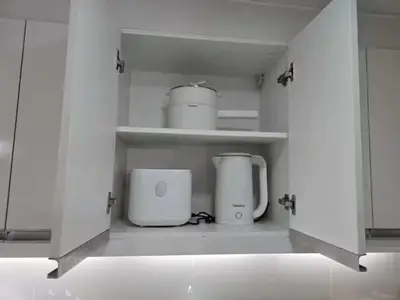 a kitchen with two appliances sitting on shelves at Modern Comfort & Snap Worthy with Pool, Gym & More in Manila