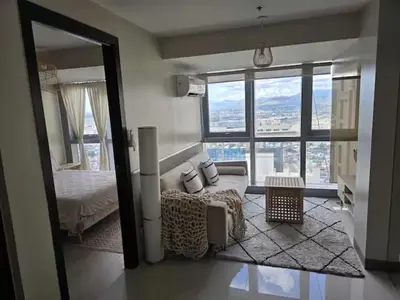 a bedroom with a bed and a large window at Modern Comfort & Snap Worthy with Pool, Gym & More in Manila