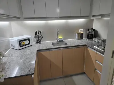a kitchen with a sink and a microwave on a counter at Modern Comfort & Snap Worthy with Pool, Gym & More in Manila