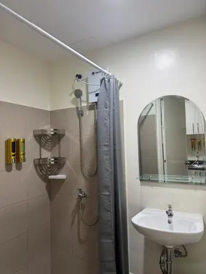 a bathroom with a shower and a sink and a mirror at Jac's Hide Out 5 in Manila