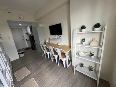 a room with a table and chairs and a television at Jac's Hide Out 5 in Manila