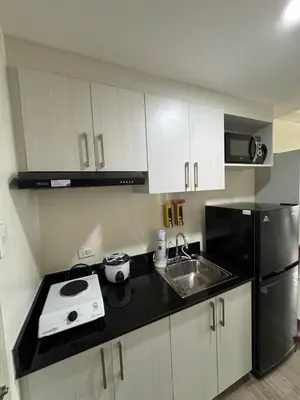 a small kitchen with a sink and a refrigerator at Jac's Hide Out 5 in Manila