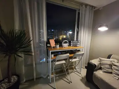 a room with a table and chairs in front of a window at Cozy 1BR Corner with Panoramic City Skyline View in Manila