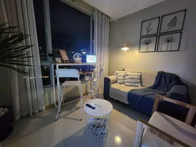 a living room with a bed and a desk in it at Cozy 1BR Corner with Panoramic City Skyline View in Manila