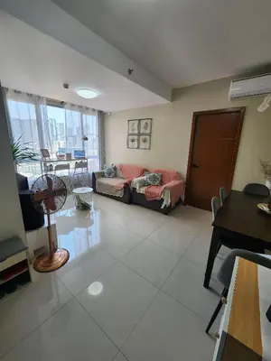 a living room with a couch and a table at Cozy 1BR Corner with Panoramic City Skyline View in Manila