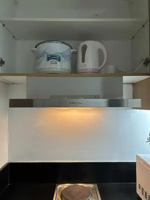 a kitchen with a stove top oven with a appliance at Shell Residences MOA - Josh staycation in Manila