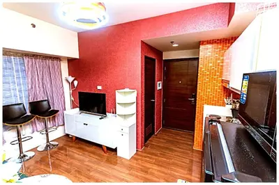 a living room with red walls and a desk and chairs at 2 bedroom fantastic air condo 3649 swim gym surf 300 MB in Manila