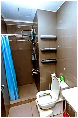a small bathroom with a toilet and a shower at 2 bedroom fantastic air condo 3649 swim gym surf 300 MB in Manila