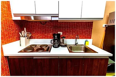 a kitchen counter with a sink and a stove at 2 bedroom fantastic air condo 3649 swim gym surf 300 MB in Manila