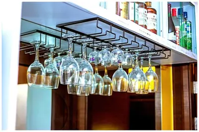 a bunch of wine glasses hanging from a rack at 2 Bedroom Green Yellow luxury 5549 Makati 300Mb swim in Manila