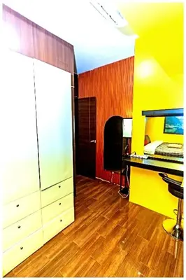 a room with a bedroom with a yellow wall and a desk at 2 Bedroom Green Yellow luxury 5549 Makati 300Mb swim in Manila