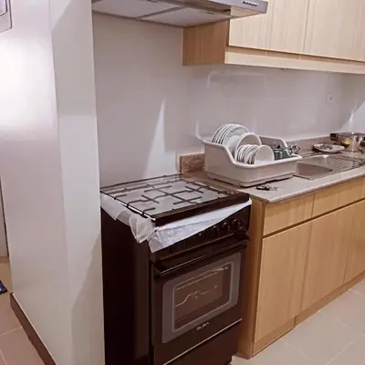 a kitchen with a stove top oven next to a counter at Short stay near NAIA in Manila