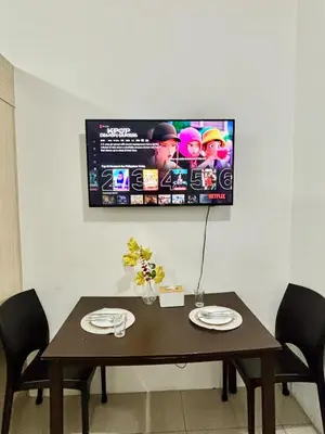 a dining room table with a television on the wall at Resort-Style Living in Makati in Manila