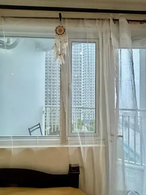 a bedroom with a window with white curtains at Resort-Style Living in Makati in Manila