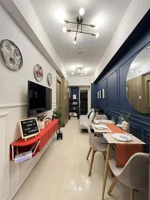 a living room with a dining table and a tv at Casa Florencia at SDMC Coast Residences in Manila