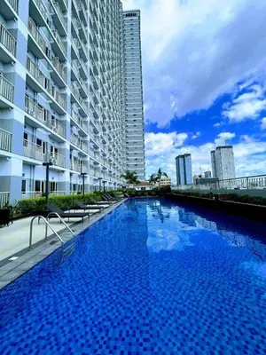 a large swimming pool next to a tall building at Casa Florencia at SDMC Coast Residences in Manila