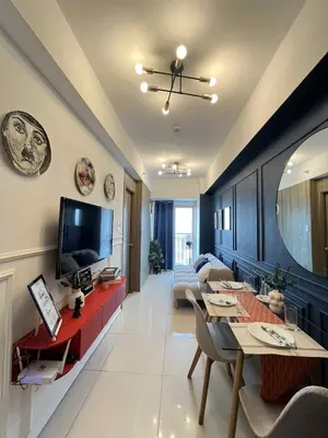 a living room with a couch and a television at Casa Florencia at SDMC Coast Residences in Manila