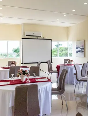 a conference room with two tables and a white screen at Cozy Studio near Nuvali, Enchanted Kingdom - Private Cinema with Netflix & Disney Plus with Free Pool Access in Silang