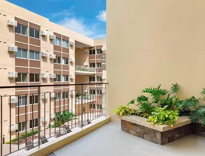 a balcony of a apartment building with plants at Cozy Studio near Nuvali, Enchanted Kingdom - Private Cinema with Netflix & Disney Plus with Free Pool Access in Silang
