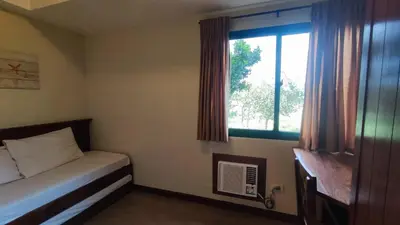 a small bedroom with a bed and a window at Peaceful 2BR Home in Paranaque Airport Area in Manila