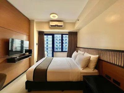a hotel room with a bed and a television at Studio Condo by Sea Residences near MOA 03 in Manila
