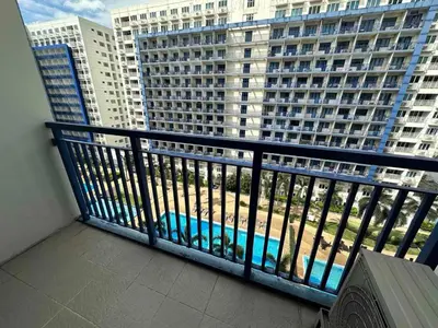 a balcony with a view of a large building at Studio Condo by Sea Residences near MOA 03 in Manila