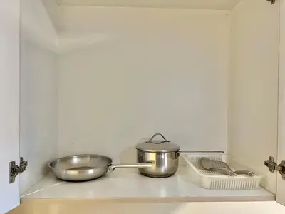a kitchen counter with two pots and pans on it at Studio Condo by Sea Residences near MOA 03 in Manila