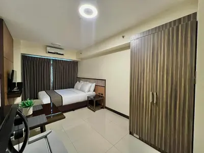 a hotel room with a bed and a desk and a bedroom at Studio Condo by Sea Residences near MOA 03 in Manila