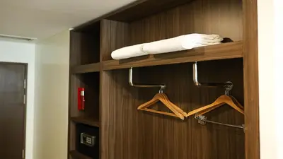 a wooden closet with hangers and a towel at Private Rooms in Historic Manila Chinatown in Manila