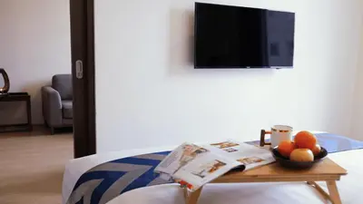 a bed with a table with a bowl of fruit on it at Private Rooms in Historic Manila Chinatown in Manila