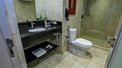 a bathroom with a toilet and a sink and a shower at Business & Leisure Stay in Eastwood City in Manila