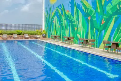 a large swimming pool with chairs and a mural at Business & Leisure Stay in Eastwood City in Manila