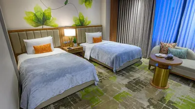 a hotel room with two beds and a couch at Business & Leisure Stay in Eastwood City in Manila