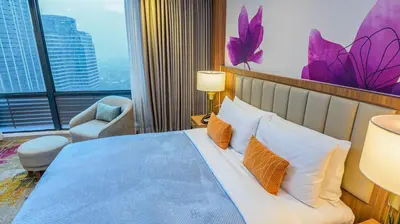 a hotel room with a bed and a large window at Business & Leisure Stay in Eastwood City in Manila