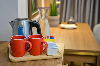 two coffee mugs on a wooden tray on a table at Business & Leisure Stay in Eastwood City in Manila